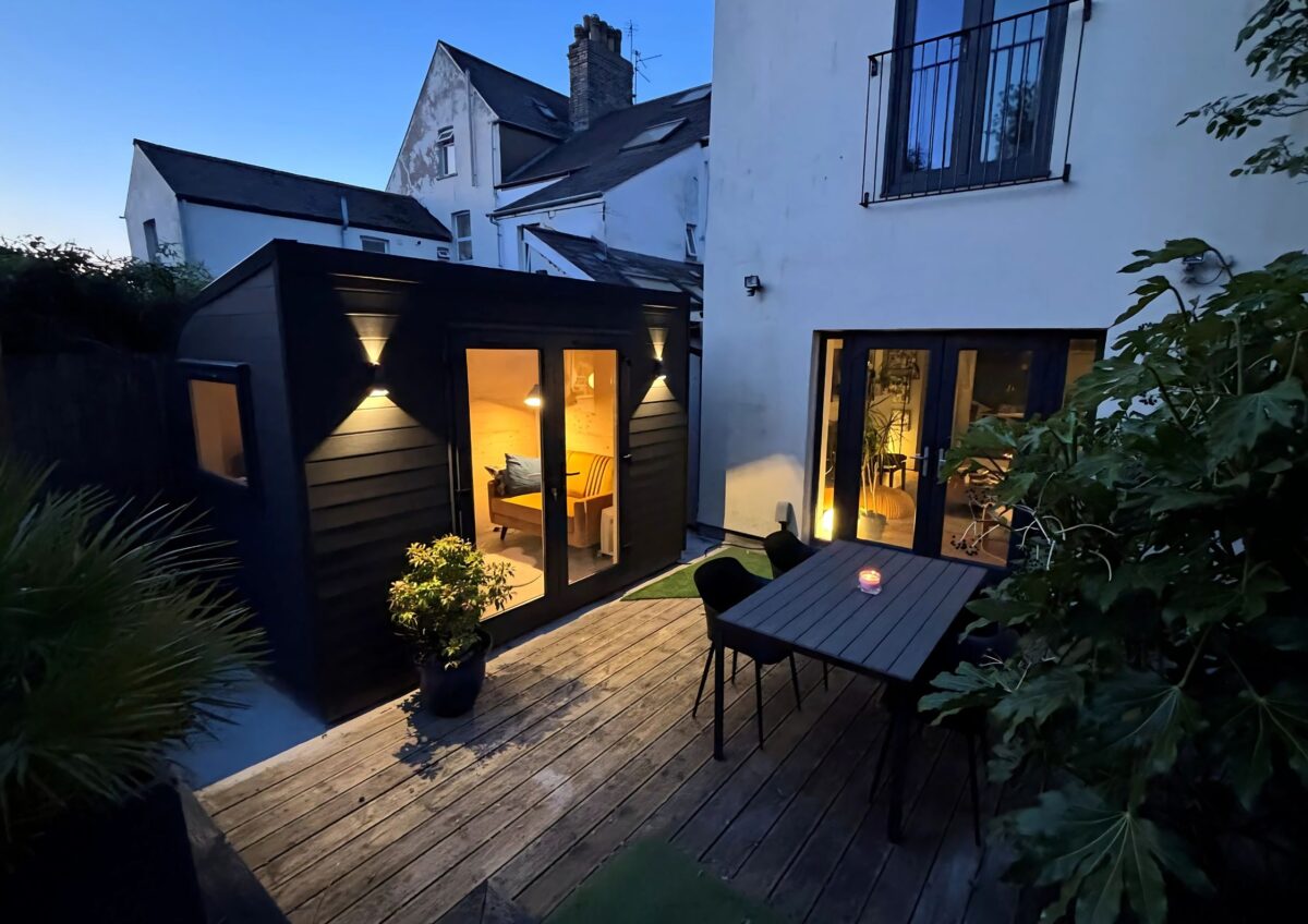 eSnug Plus garden studio with double French doors and exterior lighting installed in Cardiff garden with composite cladding