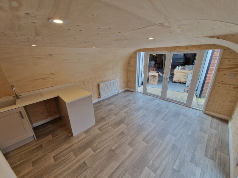 Open plan living space with kitchenette inside an eLodge Max garden lodge