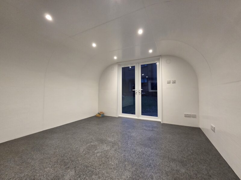 Front view of eLodge Max garden lodge with double doors, dimmable lights, and Wi-Fi